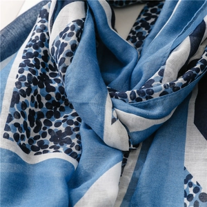 Detail view of lightweight blue and white geometric floral print scarf texture