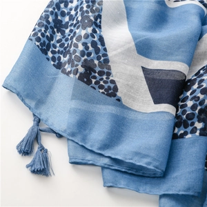 Detail of blue geometric leopard print scarf with soft fringe trim and lightweight texture