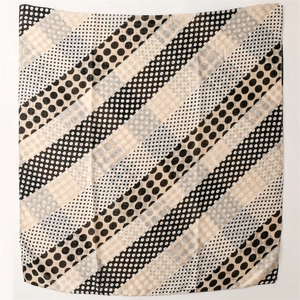 Detail of soft cotton-feel scarf showing black and beige polka dot with stripe patterns