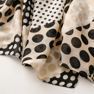Close-up of soft cotton linen feel scarf featuring polka dot pattern and frayed edges