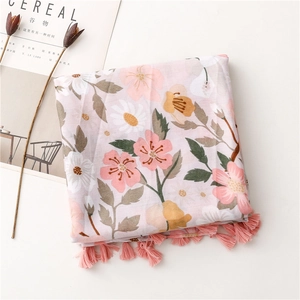 Close-up of pink floral scarf with white daisy prints and handmade fringe tassel trim