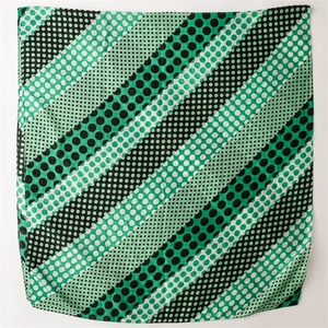 Detail of mint green and black polka dot striped cotton-linen blend scarf with frayed edges