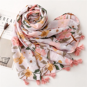 Close-up of pink floral scarf with delicate fringe edges and breathable linen texture
