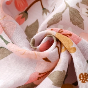 Detailed close-up of soft pink floral fabric texture for summer beach shawls