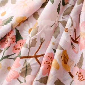 Close-up of lightweight pink floral scarf fabric with detailed yellow flower patterns