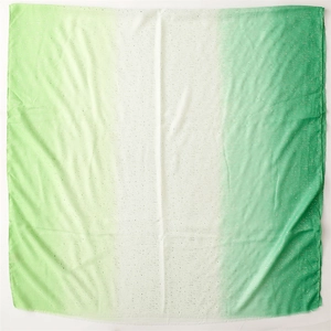 Close-up of green gradient linen scarf featuring silver glitter and fringe edge details