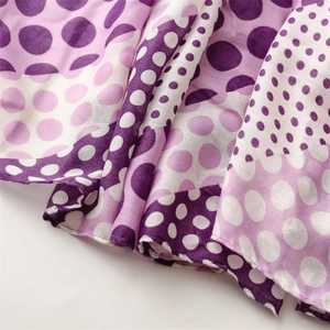 Macro shot of purple polka dot cotton linen scarf showing soft fabric texture and frayed edges