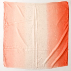 Detail of gradient coral orange scarf with glitter texture and frayed edges