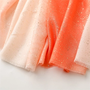 Detailed macro of pink gradient scarf with gold glitter finish and fringe edge