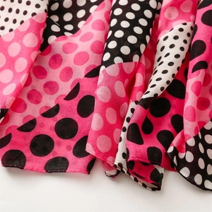 Close-up of pink and black polka dot scarf featuring soft fabric with fine stitched edges
