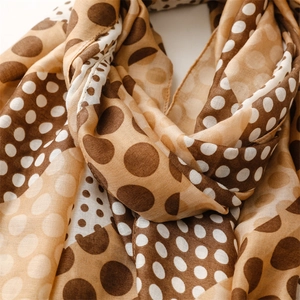Detail of soft cotton-linen feel scarf featuring elegant brown and beige polka dot patterns