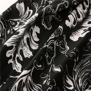 Close-up of black cotton-linen shawl fabric with white tropical leaf prints and textures