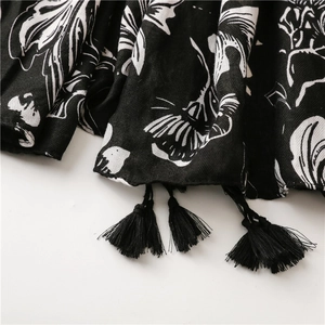Close-up of vintage floral print scarf with soft texture and black tassel fringe details