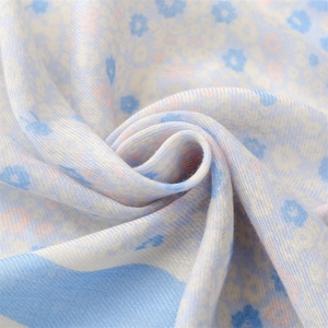 Close-up of soft blue floral cotton-linen fabric texture with delicate flower patterns