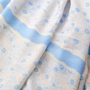Close-up of light blue floral cotton linen scarf showing delicate fabric texture and patterns