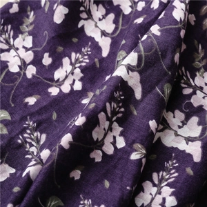 Detailed macro view of the soft floral fabric with purple background and green leaf patterns