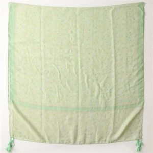 Detailed view of lightweight mint green floral scarf with decorative corner tassels