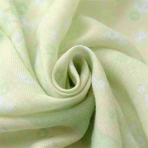 Detailed macro view of soft light green floral fabric with small white flowers pattern