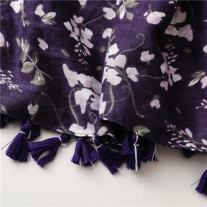 Detailed close-up of dark purple floral sun scarf with elegant fringed edges and tassels