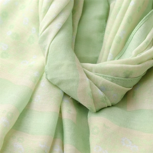 Detail of light green floral scarf with soft cotton-linen texture and delicate flower prints