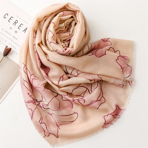 Detail of vintage floral scarf with delicate fringe edges and soft artistic texture
