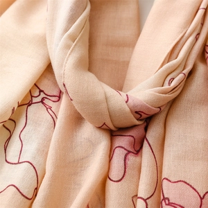 Macro shot of abstract floral patterns on soft beige lightweight textured silk scarf