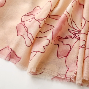 Detailed view of vintage floral scarf with delicate red blossoms and frayed edges