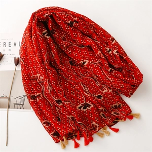 Detail of red floral cotton scarf with white dots and colorful fringe tassels