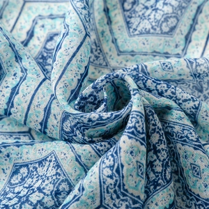 Macro detail of blue geometric patterns on soft cotton-linen fabric with woven texture