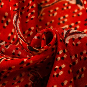 Detailed macro view of soft red ethnic scarf with black and white polka dot floral prints