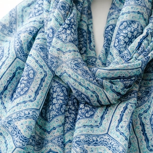 Close-up of soft cotton linen scarf showing blue geometric floral patterns and texture