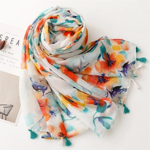 Detail of colorful floral cotton linen scarf with fine turquoise and white fringe tassels