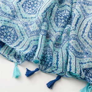 Close-up of blue geometric print scarf with delicate tassels and cotton-linen texture