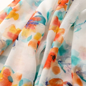 Macro detail of artistic watercolor floral scarf showing soft cotton-linen fabric texture