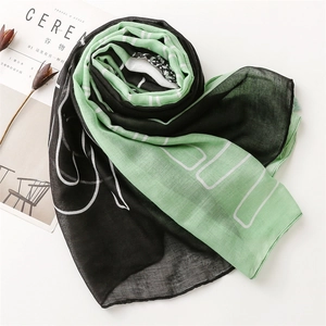 Détail de l'écharpe en coton et lin bicolore vert et noir avec bords à franges