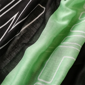 Vue macro de la texture de l'écharpe en coton et lin avec blocs verts et imprimés lettres