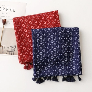 Détail de foulards en coton lin rouge et bleu avec motifs d'étoiles et pompons