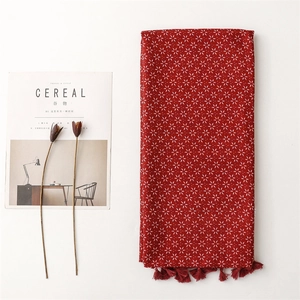 Détail de l'écharpe bohème rouge avec motifs floraux flocons de neige et bords frangés