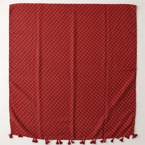 Détail du châle bohème rouge avec motifs d'étoiles blanches et bords à franges