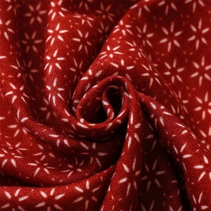 Vue détaillée de l'écharpe vintage en coton rouge avec motifs d'étoiles et texture riche