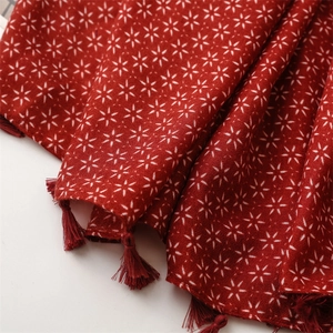 Vue détaillée d'une écharpe rouge en coton et lin avec motifs étoiles et franges