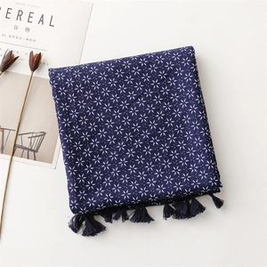 Détail de l'écharpe en coton et lin bleu marine avec motifs étoiles et pompons