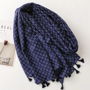 Détail d'une écharpe bleu foncé avec motifs d'étoiles blanches et franges bohèmes