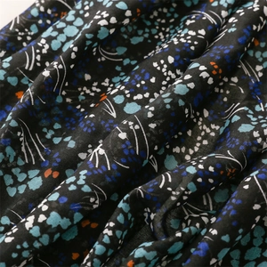 Macro shot of ethnic floral print fabric with tassels and navy cotton-linen texture