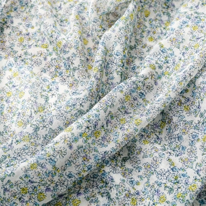 Detail of light blue floral cotton linen scarf showing soft fabric texture and print