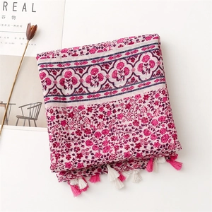 Detail of rose floral print and handmade fringe tassels on soft cotton-feel scarf