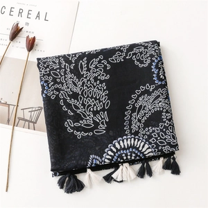 Detail of bohemian navy blue shawl with white patterns and handmade fringe tassels