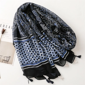 Ethnic paisley beach shawl with blue tassels and geometric patterns on a black background