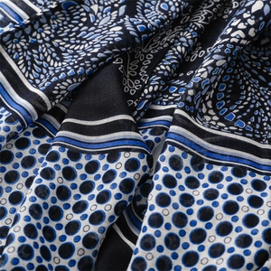 Macro shot of navy paisley and polka dot patterns on light cotton beach shawl fabric