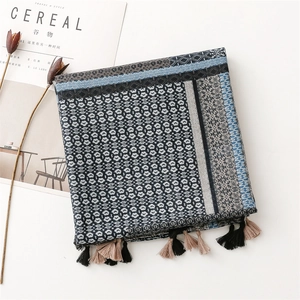 Detail of geometric pattern linen scarf with bicolor tassels and woven texture